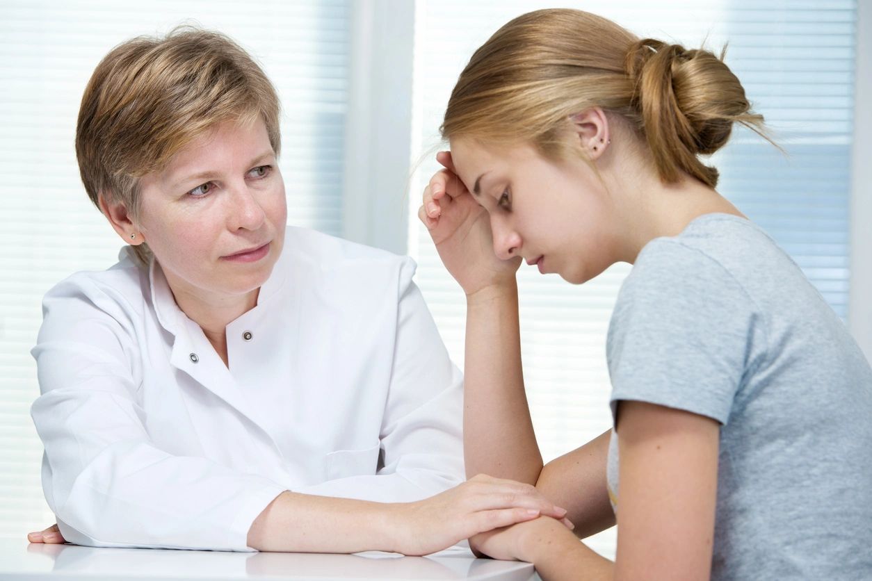 A woman sitting next to a doctor in front of a table.